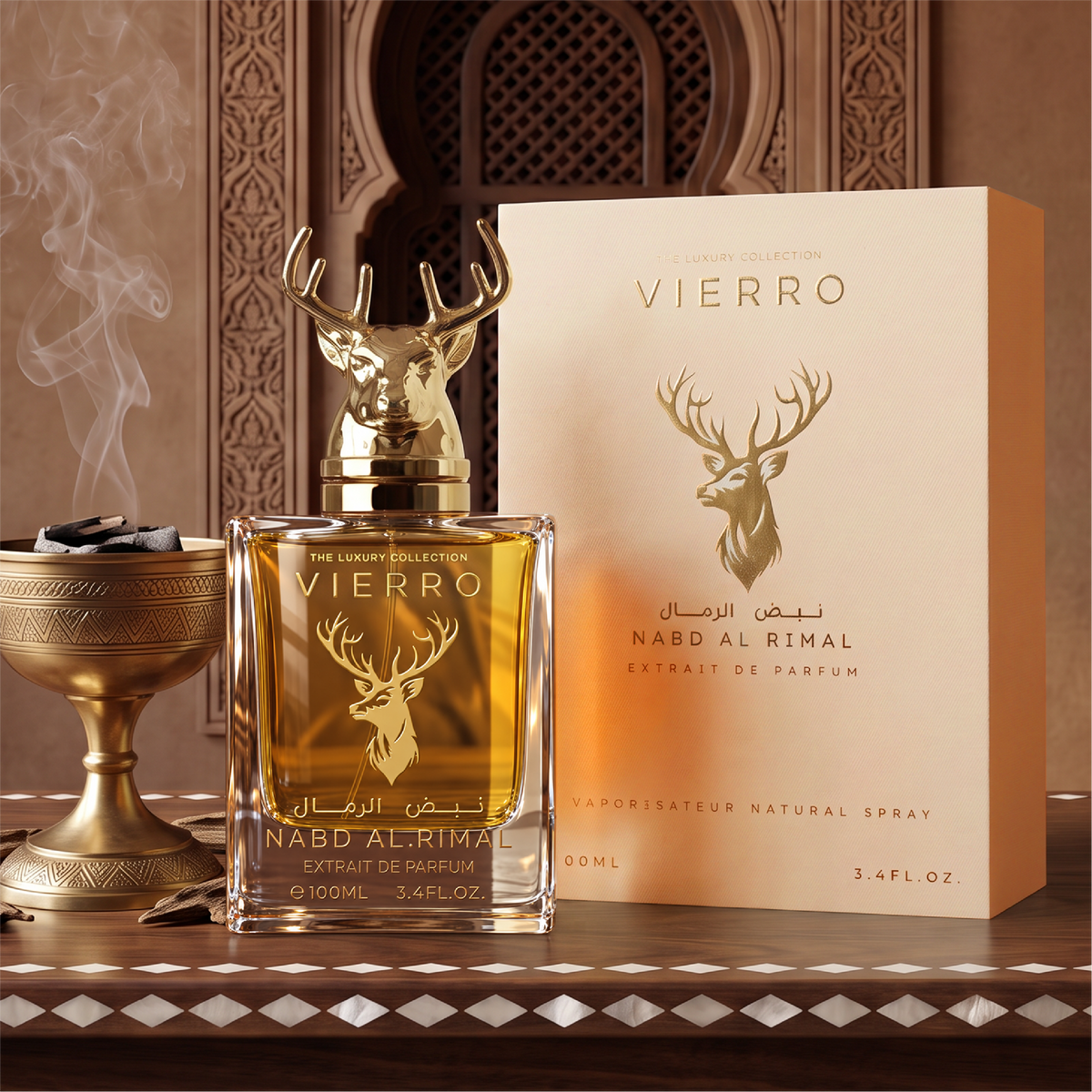 A 100ml bottle of NABD AL RIMAL Extrait de Parfum by Vierro featuring a gold deer head cap next to its matching product box on an ornate wooden surface with an incense burner in the background.